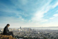 Man with laptop above city - cloud computing