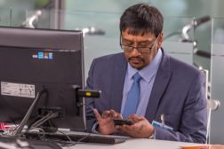 Man sits at computer facing camera