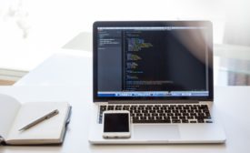 Empty desk with computer displaying code