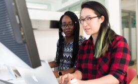 Two people use computer