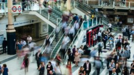 blurred image of people moving through mall