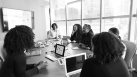 group of women sitting around an office table