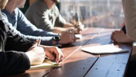 group sitting around wooden table planning