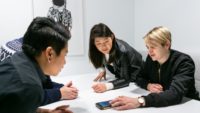 four people working together over a table