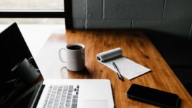 desk with laptop, coffee and notepad