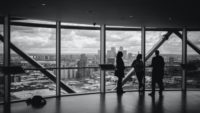 black and white image of people talking in front of window