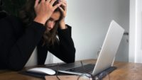 woman sitting at desk stressed out