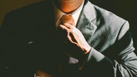 man in suit adjusting his tie