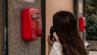 person using red emergency phone