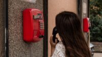 person using red emergency phone