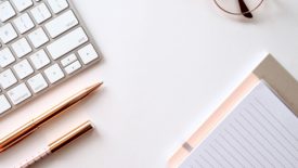 desk with keyboard and notebooks