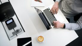 someone working at table with a cup of coffee