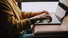 person in yellow sweater using computer