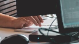 person working at desk with computer monitor