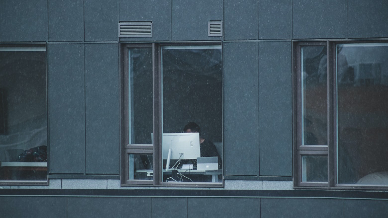 person working on computer near a window