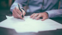 person in blue shirt filling out paperwork