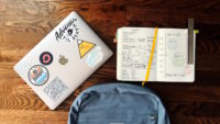 notebook, laptop and backpack on desk