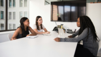 Three women sitting around a desk