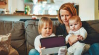 Parent watching children play on ipad