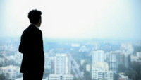 Man in suit looking out at city