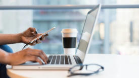 Woman working on phone and laptop