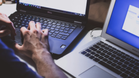 Man working on two laptops