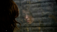 Woman looking at reflection in rain