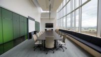 Conference rom with large windows and green cabinets