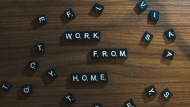 Black letter beads that spell out 'work from home' on wooden table