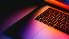 Laptop open with orange, purple and pink light