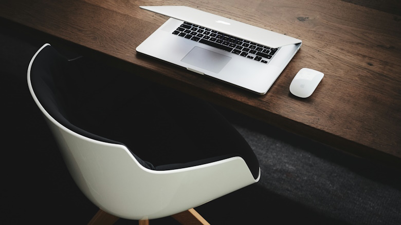 Laptop and mouse on wood desk