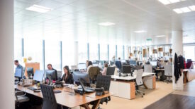 Group of people working in shared office space with large windows