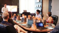 Group of people working together at board room table