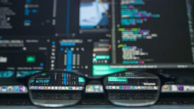 Glasses resting on desk in front of computer screen