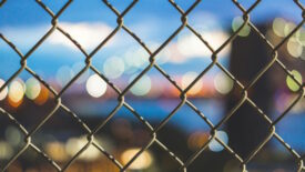 Chain-link fence with city views behind it