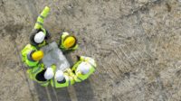 Workers reviewing building plans on job site