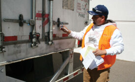 A Ryder employee checks the securement of a load in transit